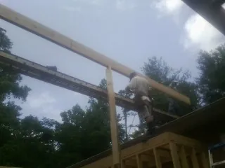 Carpenter setting a ridge beam over a new addition frame — Ice Dam Removal by Roofing Brothers in Leicester