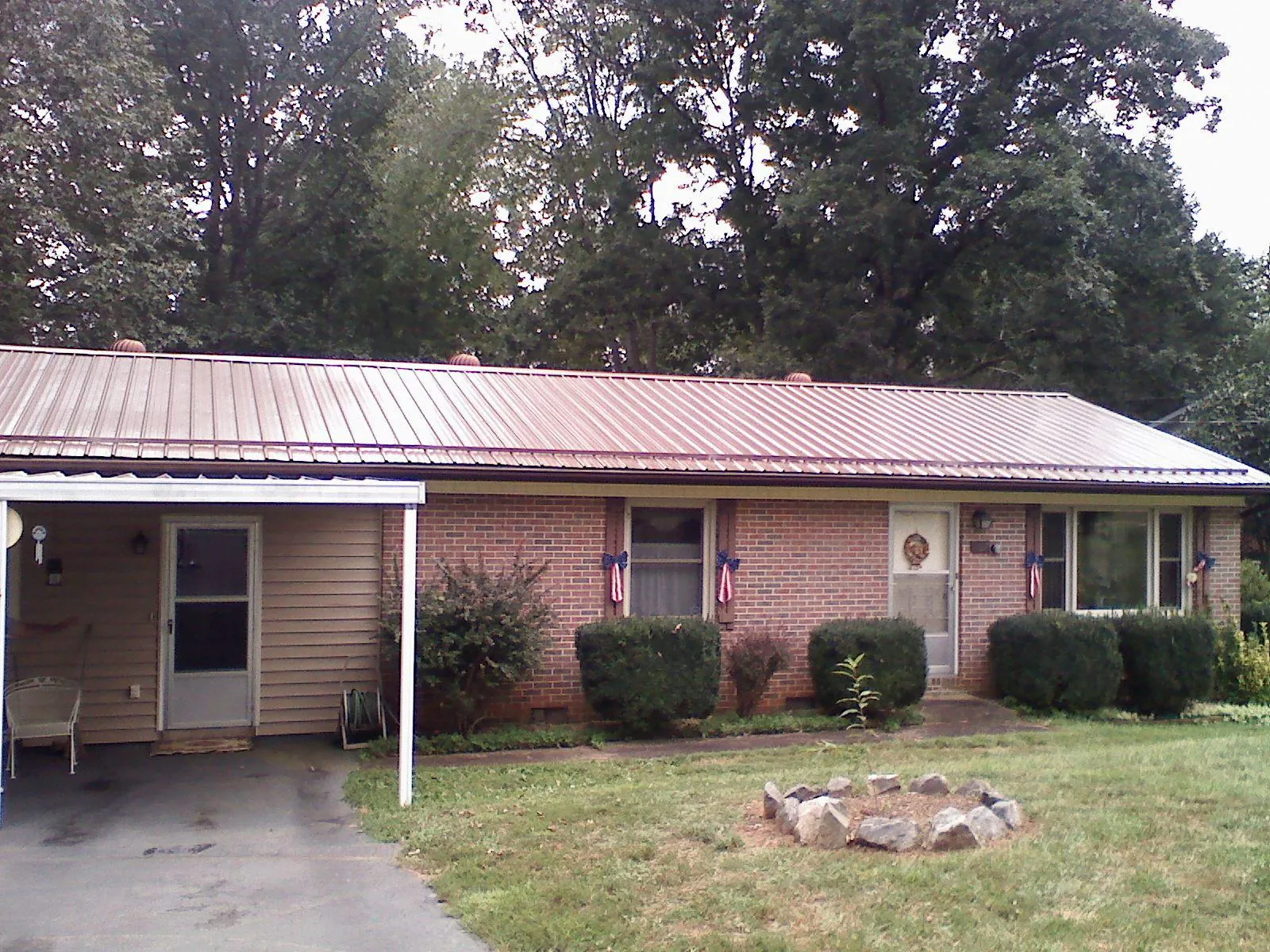 Bronze metal roof and carport on a brick ranch home in Leicester